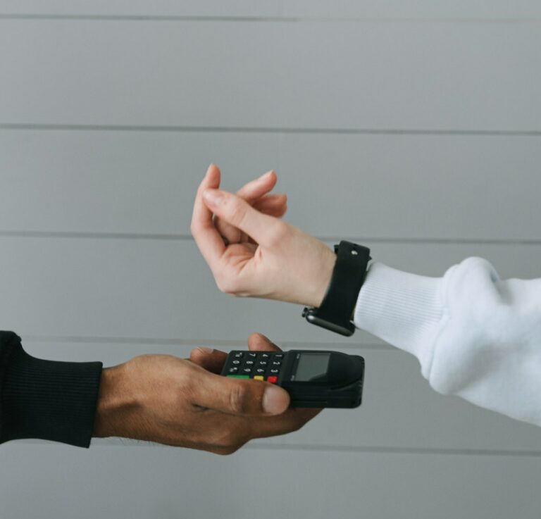 two arms held out with one holding a calculator