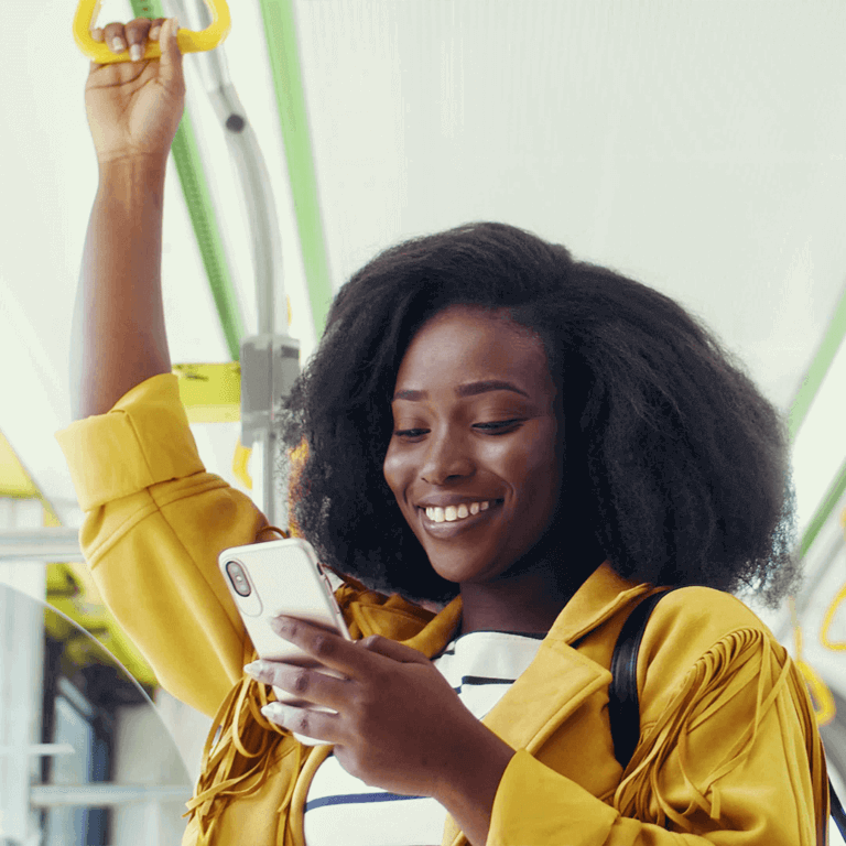 woman on a bus in a yellow jacket with a phone in her left hand