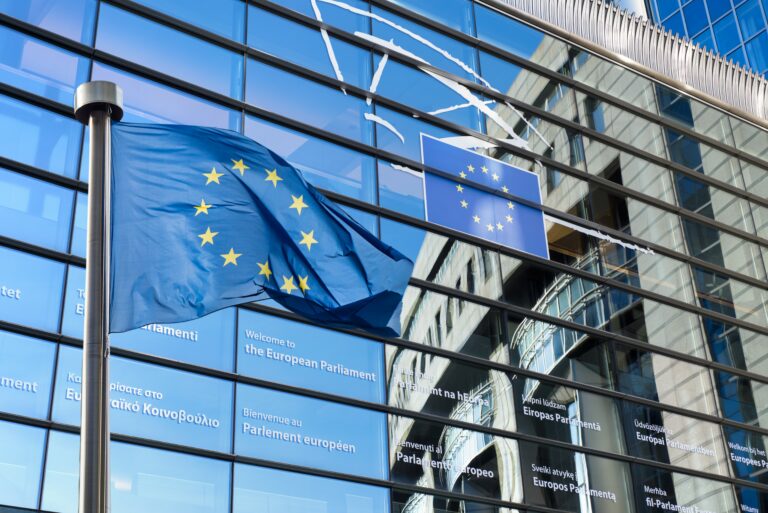 EU flag waving reflecting on the mirror of the building