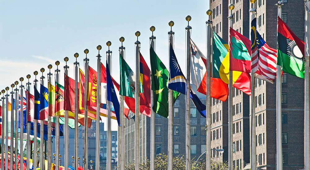 line of flag poles with flags from different countries
