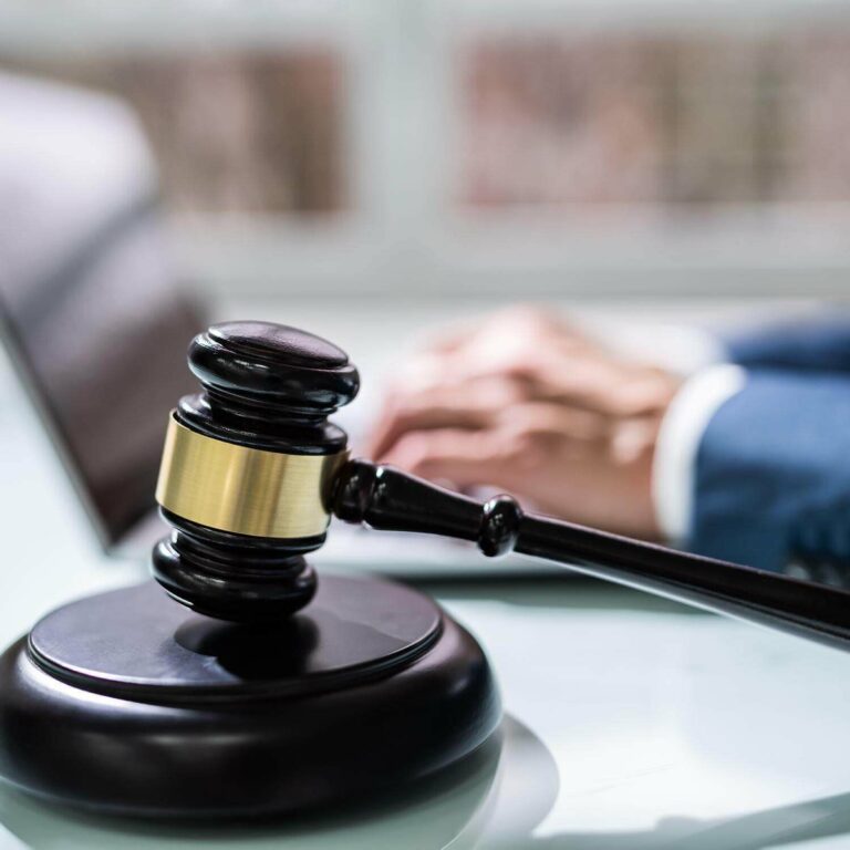 gavel sitting in front of someone working on a laptop