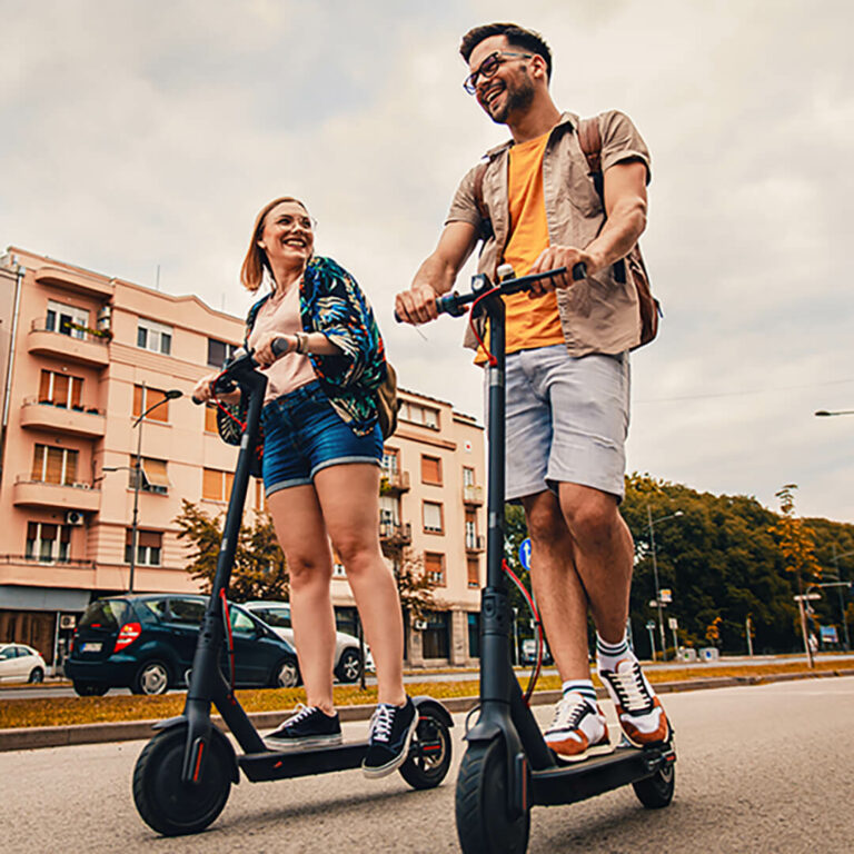 man and woman riding on escooters