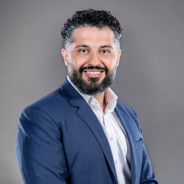 Siadat Alireza with dark hair in blue jacket and white-collared shirt