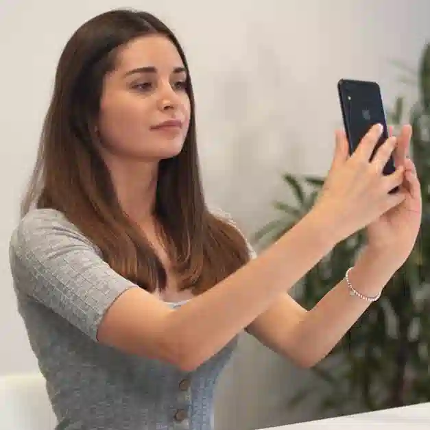 woman with brown hair holding phone up for identification check