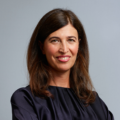 women with shoulder-length brown hair smiling at the camera in black top