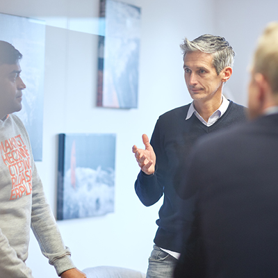 Andreas Bodczek discussing with some people in a meeting room