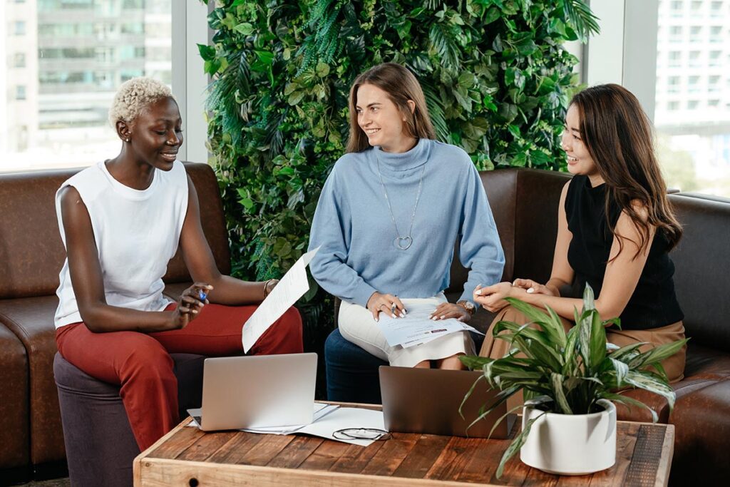 three women sitting on a couch working