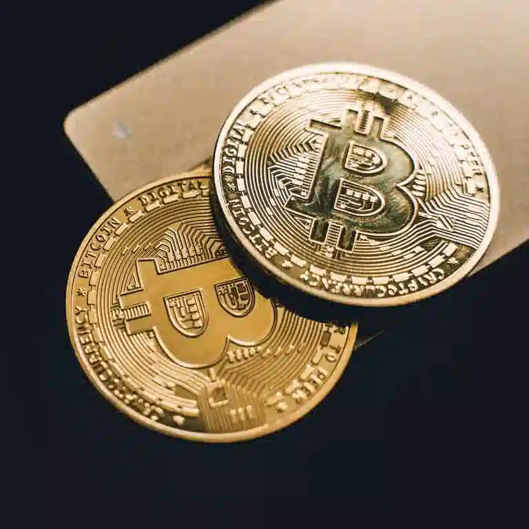 two gold bitcoins leaning against each other