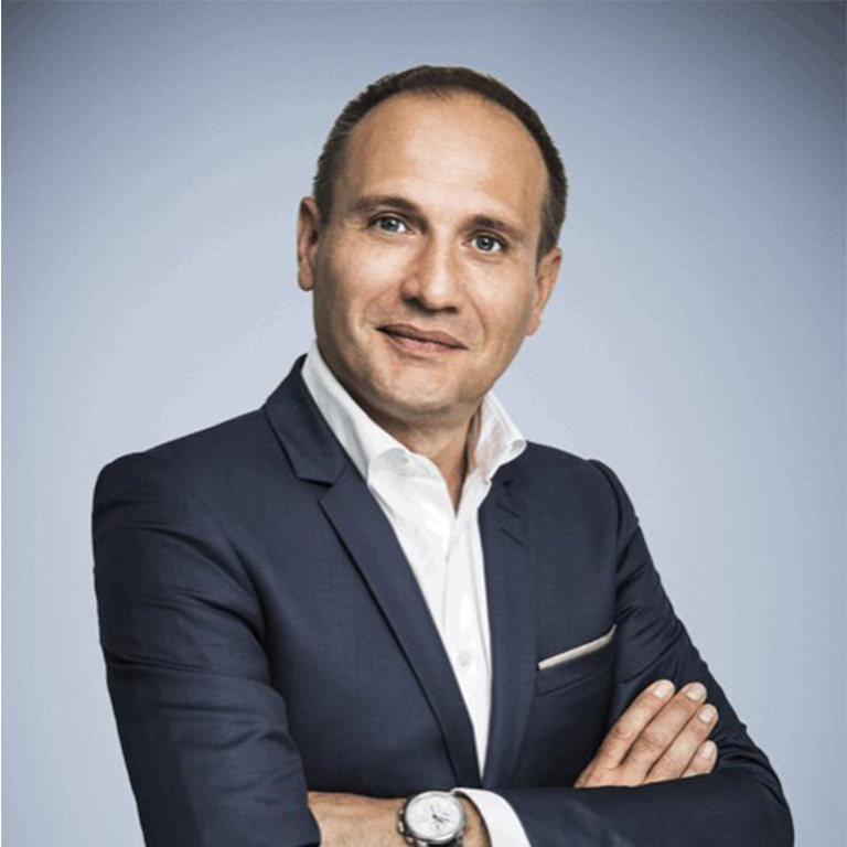 Head shot of Olivier Artus in a suit with his arms folded