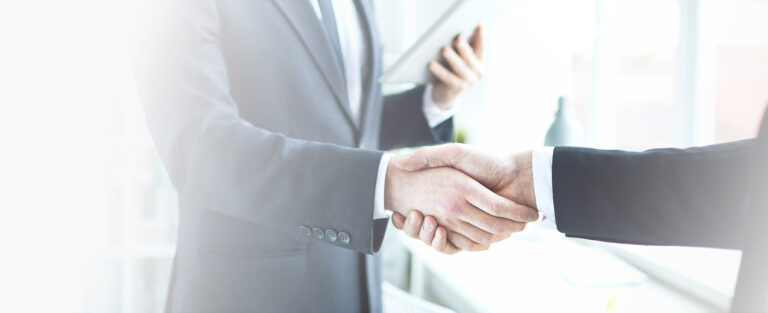 two men in suits shaking hands