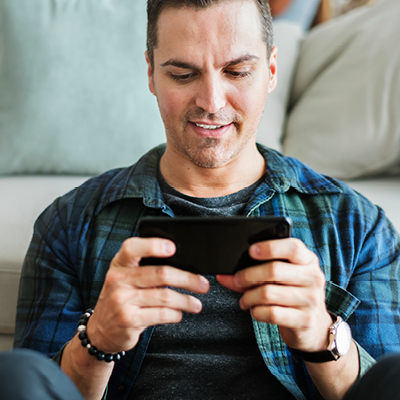 man in a living room looking at his phone