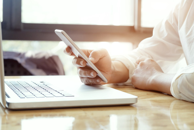 Businessman using laptop and mobile phone