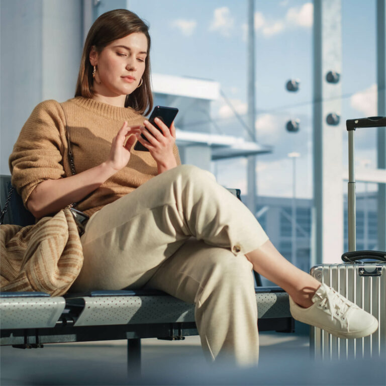 Une passagère vérifie son smartphone dans un aéroport.